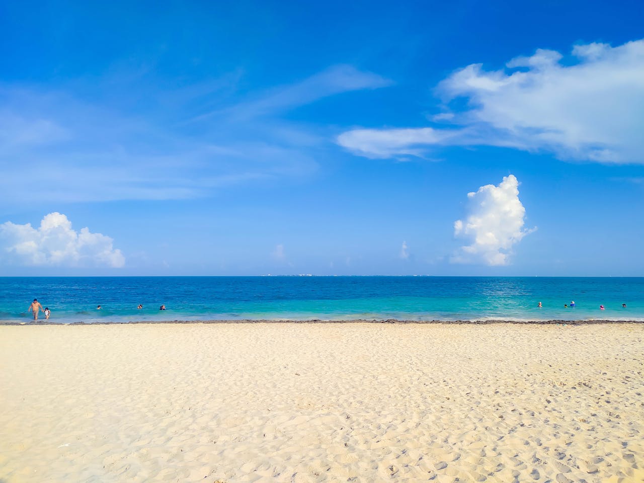 About A beautiful sunny day at CancĂșn beach with turquoise ocean and clear blue skies.